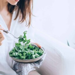 Woman eating a healthy green salad.