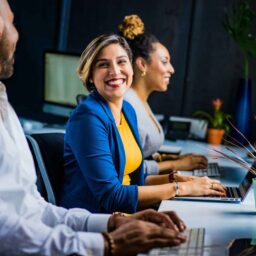 A woman smiling at her coworkers in the office.