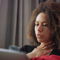 Sick woman staying at home with a sore throat.