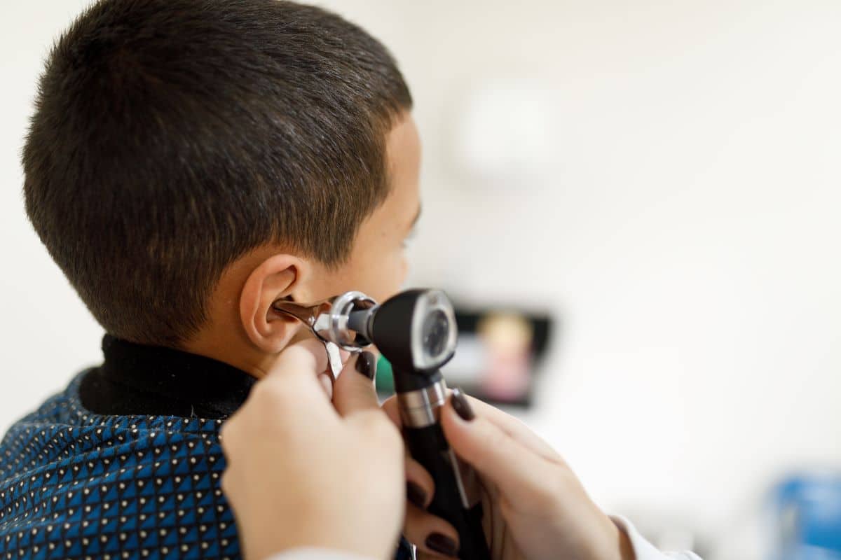 pediatric-ear-infection-diagnosis Doctor using a medical device to inspect the inner ear of a child patient