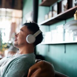 Man sitting on the couch listening to music.