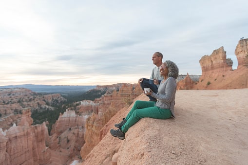 Older couple from Utah on a hike, taking a break to have a drink and enjoy the scenery.