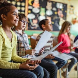 Large group of elementary students paying attention on a music class at school.